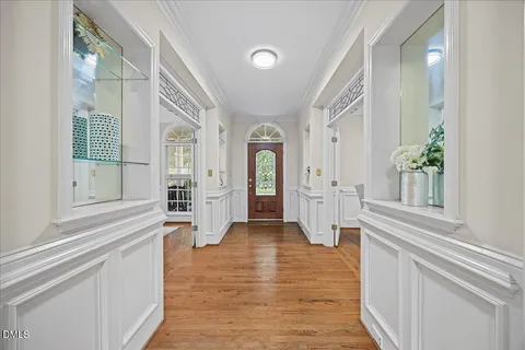 a view of a dining room with furniture a chandelier and wooden floor