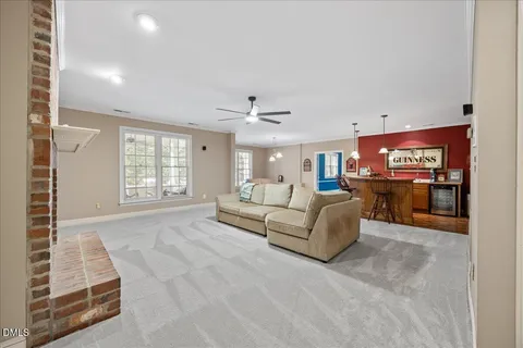 a view of a patio with table and chairs and floor to ceiling window next to a yard