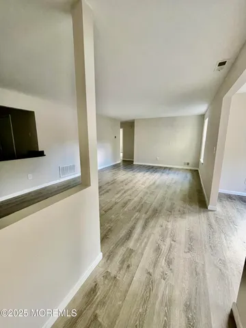 a view of a livingroom with wooden floor and a flat screen tv