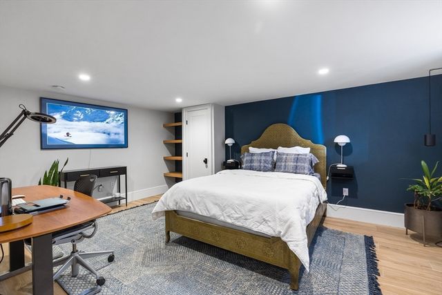 a spacious bedroom with a bed table and dresser