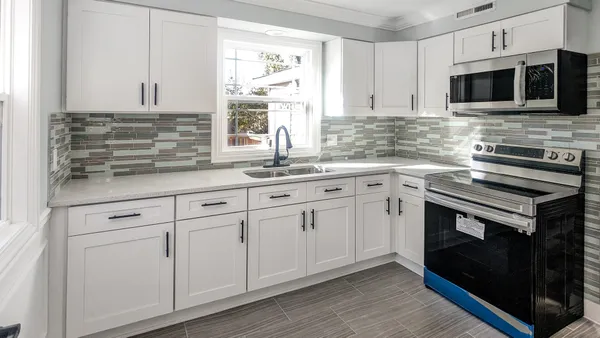 a kitchen with white cabinets stainless steel appliances and sink