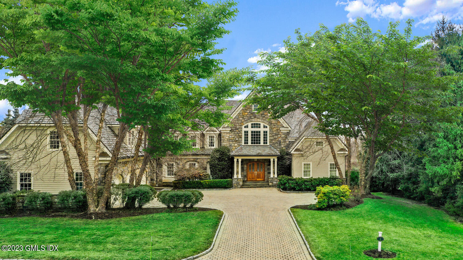 a front view of a house with a garden and trees