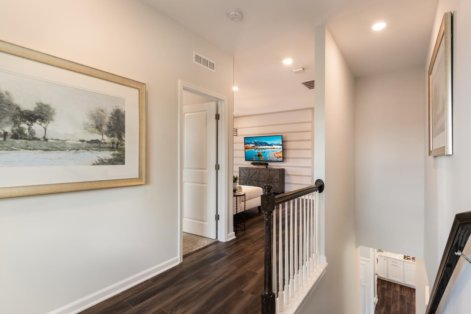 4121 Snowy Range Circle, Unit LANDRUM Raleigh, NC 27616 - Photo 16 of 27 a hallway with wooden floor and paintings on the wall