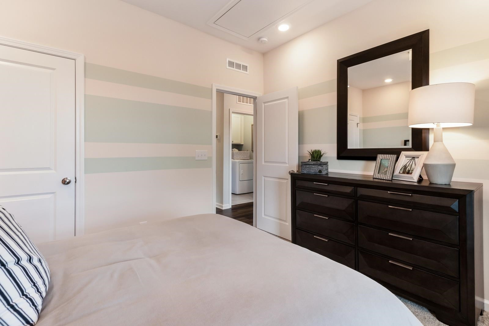 4121 Snowy Range Circle, Unit LANDRUM Raleigh, NC 27616 - Photo 26 of 27 a bedroom with a bed and a mirror
