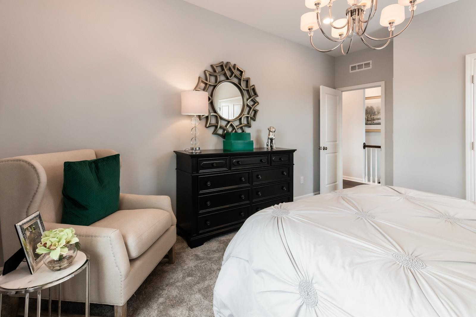 4121 Snowy Range Circle, Unit LANDRUM Raleigh, NC 27616 - Photo 27 of 27 a bedroom with a bed a chandelier and dresser