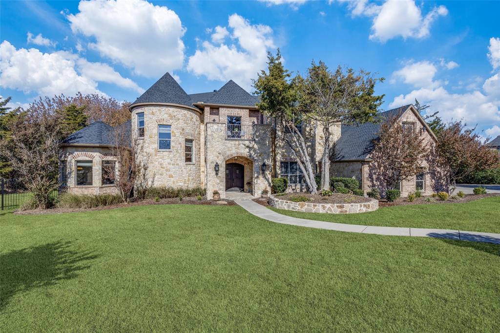 a front view of a house with a garden and trees