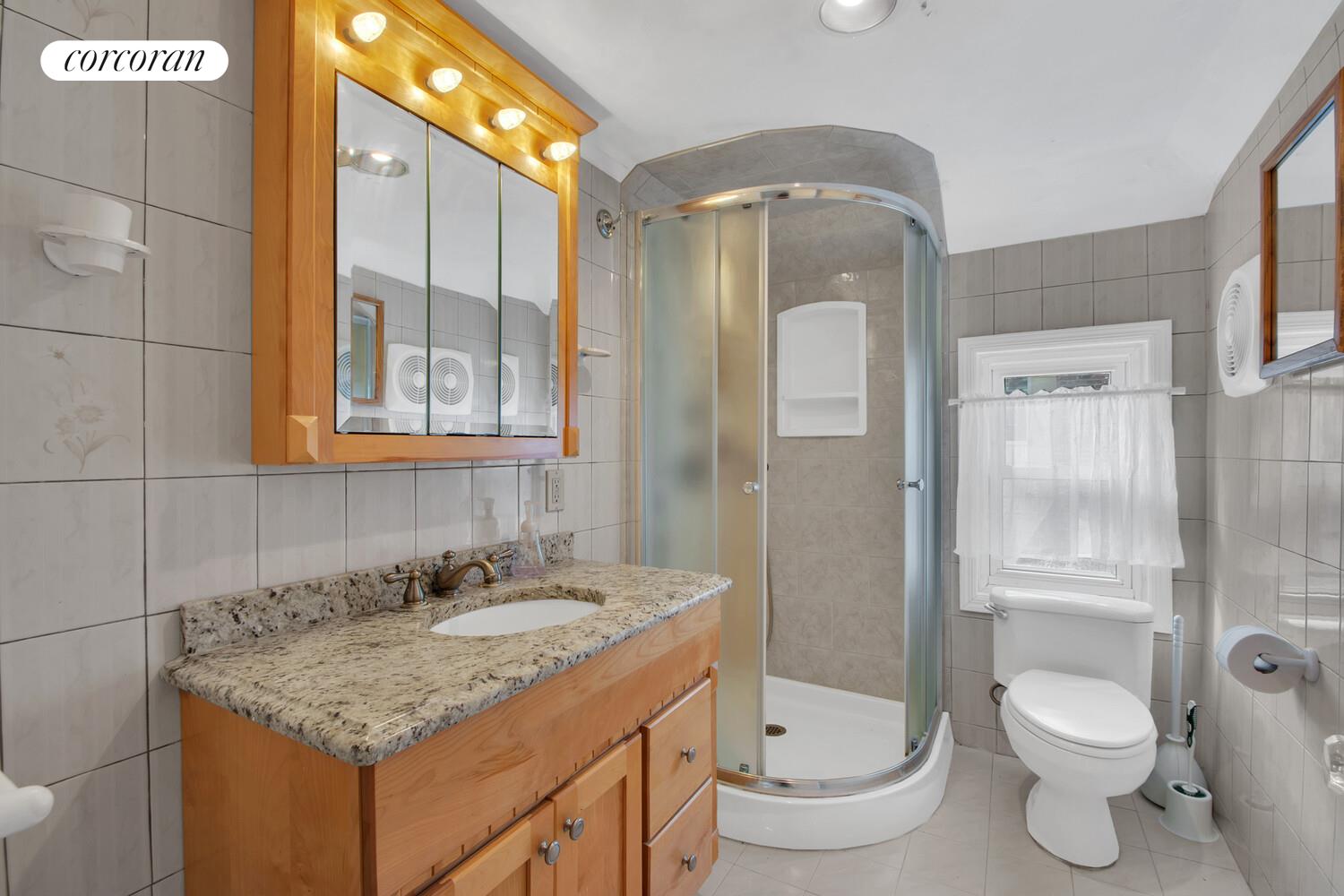 324 Beverly Road Queens, NY 11363 - Photo 14 of 20 a bathroom with a granite countertop sink toilet and shower
