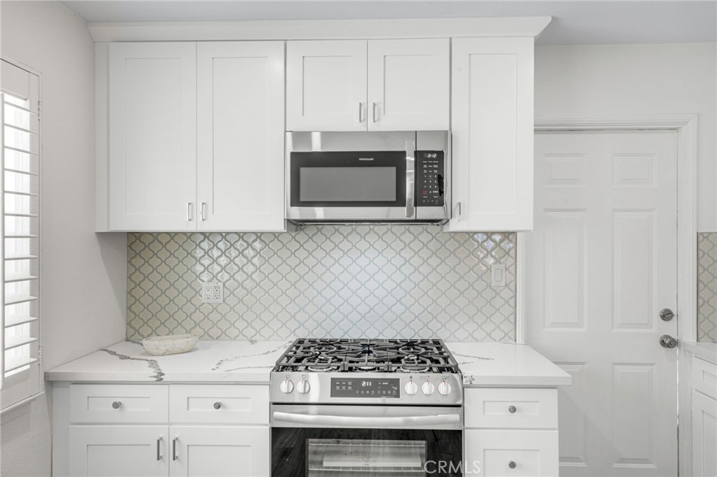13007 Duffield Avenue La Mirada, CA 90638 - Photo 10 of 33 a kitchen with granite countertop white cabinets and stainless steel appliances