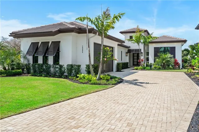 a front view of a house with a yard and potted plants