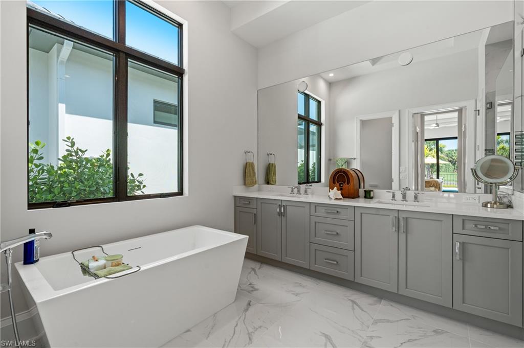 19086 Via Messina Way Miromar Lakes, FL 33913 - Photo 14 of 46 a bathroom with a tub sink and mirror