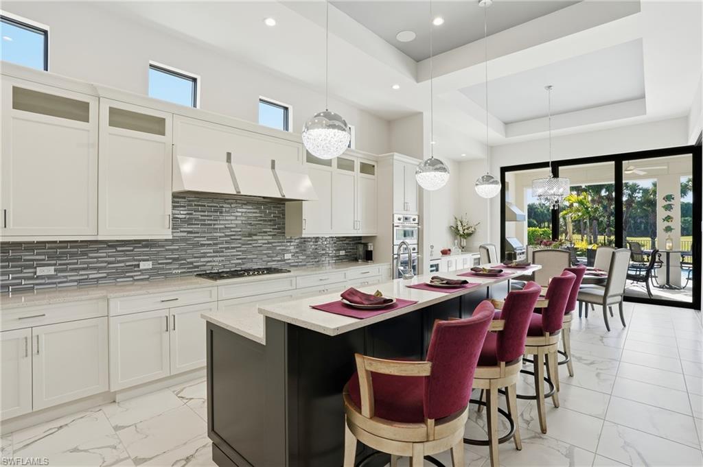19086 Via Messina Way Miromar Lakes, FL 33913 - Photo 14 of 50 a kitchen with a dining table chairs and white cabinets