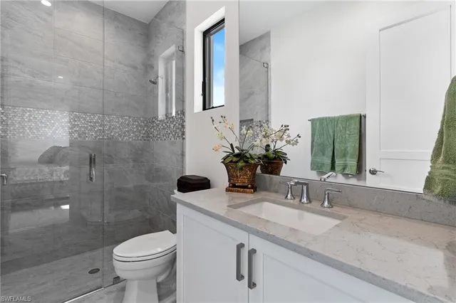 a bathroom with a sink and mirror with toilet