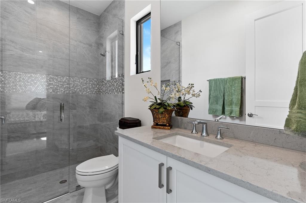 19086 Via Messina Way Miromar Lakes, FL 33913 - Photo 20 of 46 a bathroom with a sink and mirror with toilet