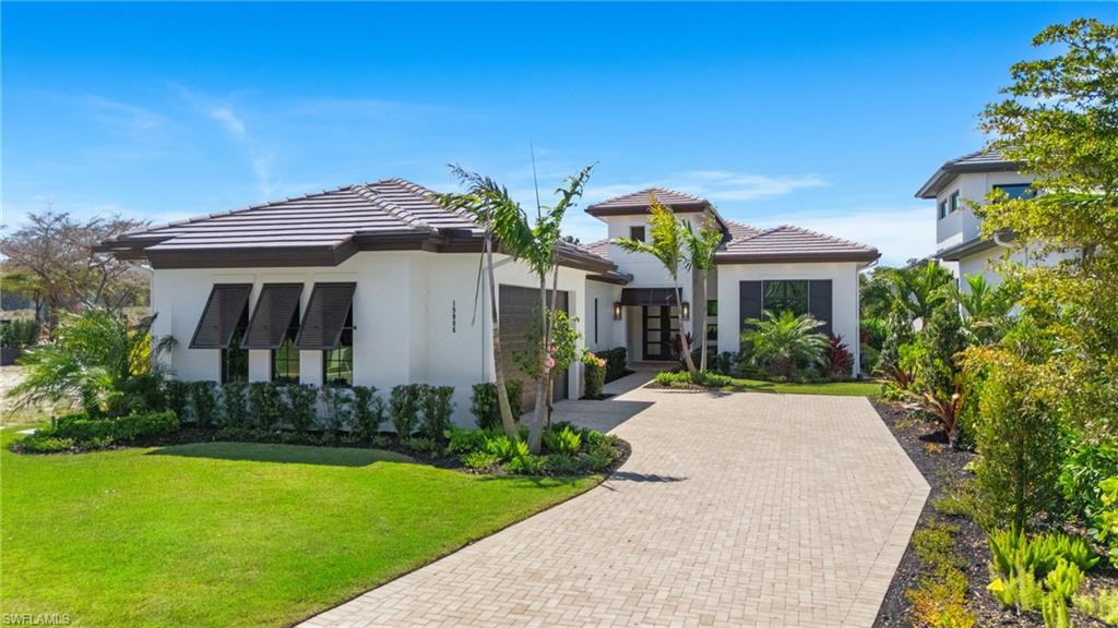 19086 Via Messina Way Miromar Lakes, FL 33913 - Photo 2 of 46 a front view of house with yard and green space
