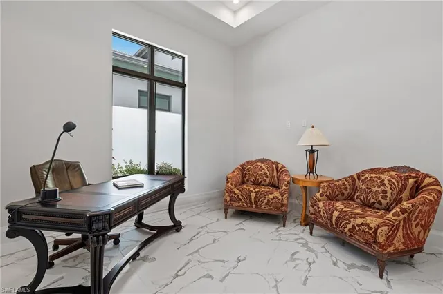a living room with furniture and two windows