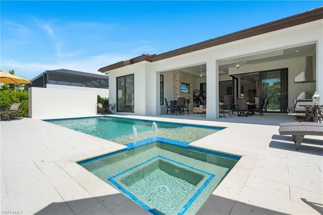 a view of a house with swimming pool and sitting area