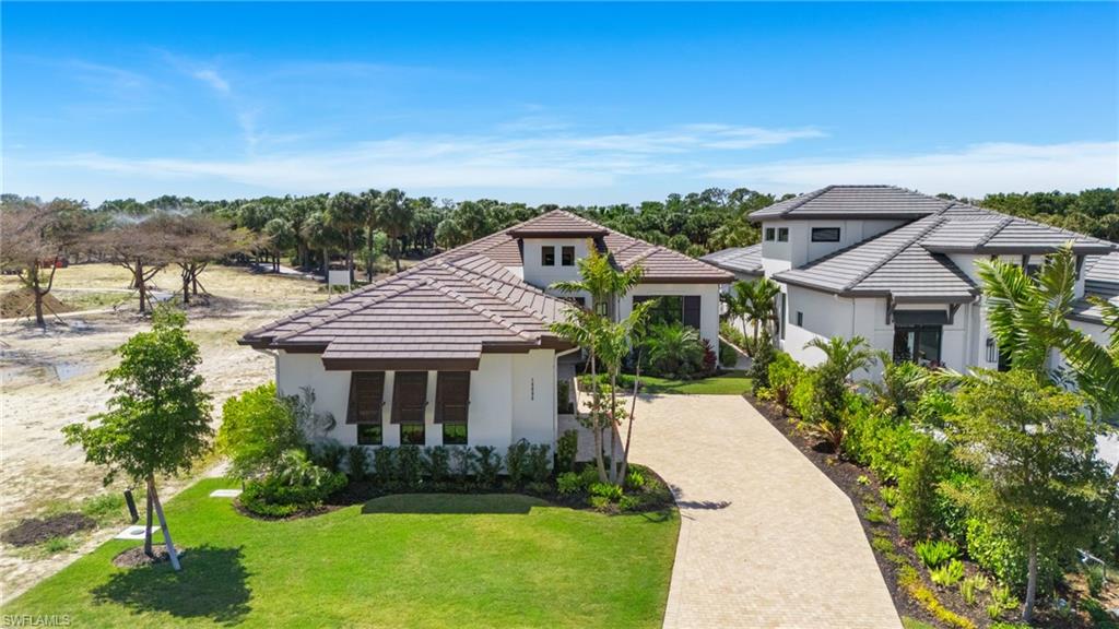 19086 Via Messina Way Miromar Lakes, FL 33913 - Photo 3 of 46 a front view of a house with a yard and potted plants