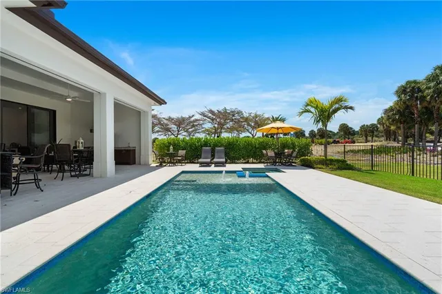 a swimming pool with outdoor seating and garden