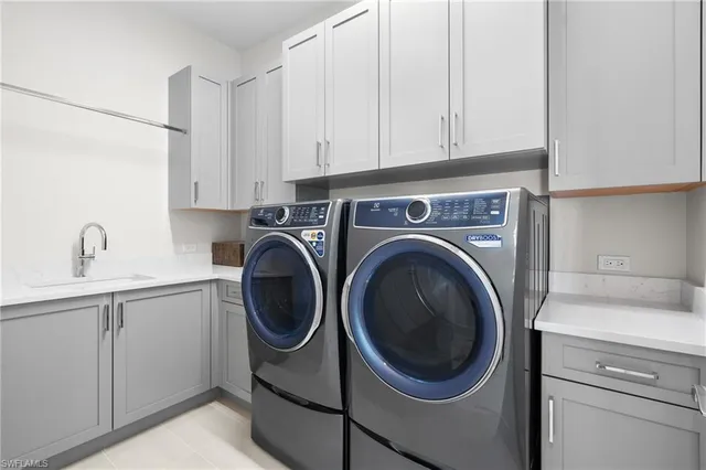 a utility room with sink dryer and washer