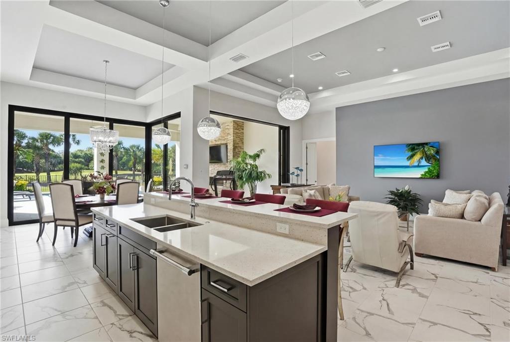 19086 Via Messina Way Miromar Lakes, FL 33913 - Photo 9 of 50 a view of a kitchen with kitchen island stainless steel appliances a sink and living room view