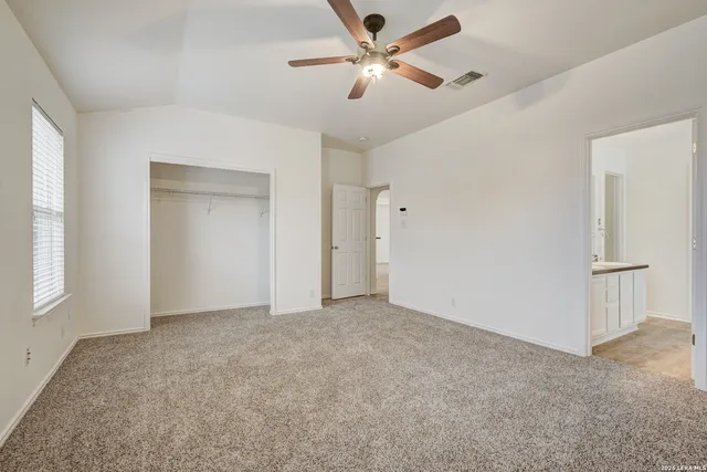 a view of an empty room and a ceiling fan window