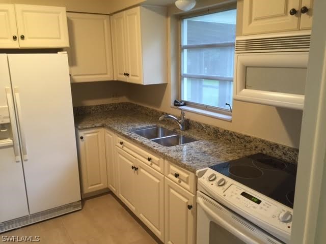 18552 Geranium Road Fort Myers, FL 33967 - Photo 8 of 20 a kitchen with granite countertop a sink and a refrigerator