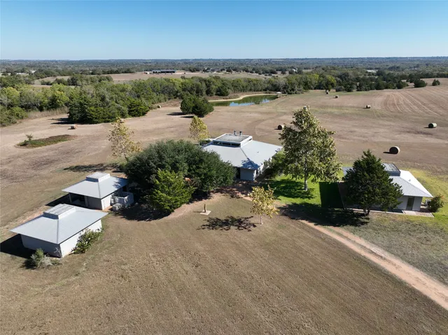 an aerial view of a house with a yard and lake view