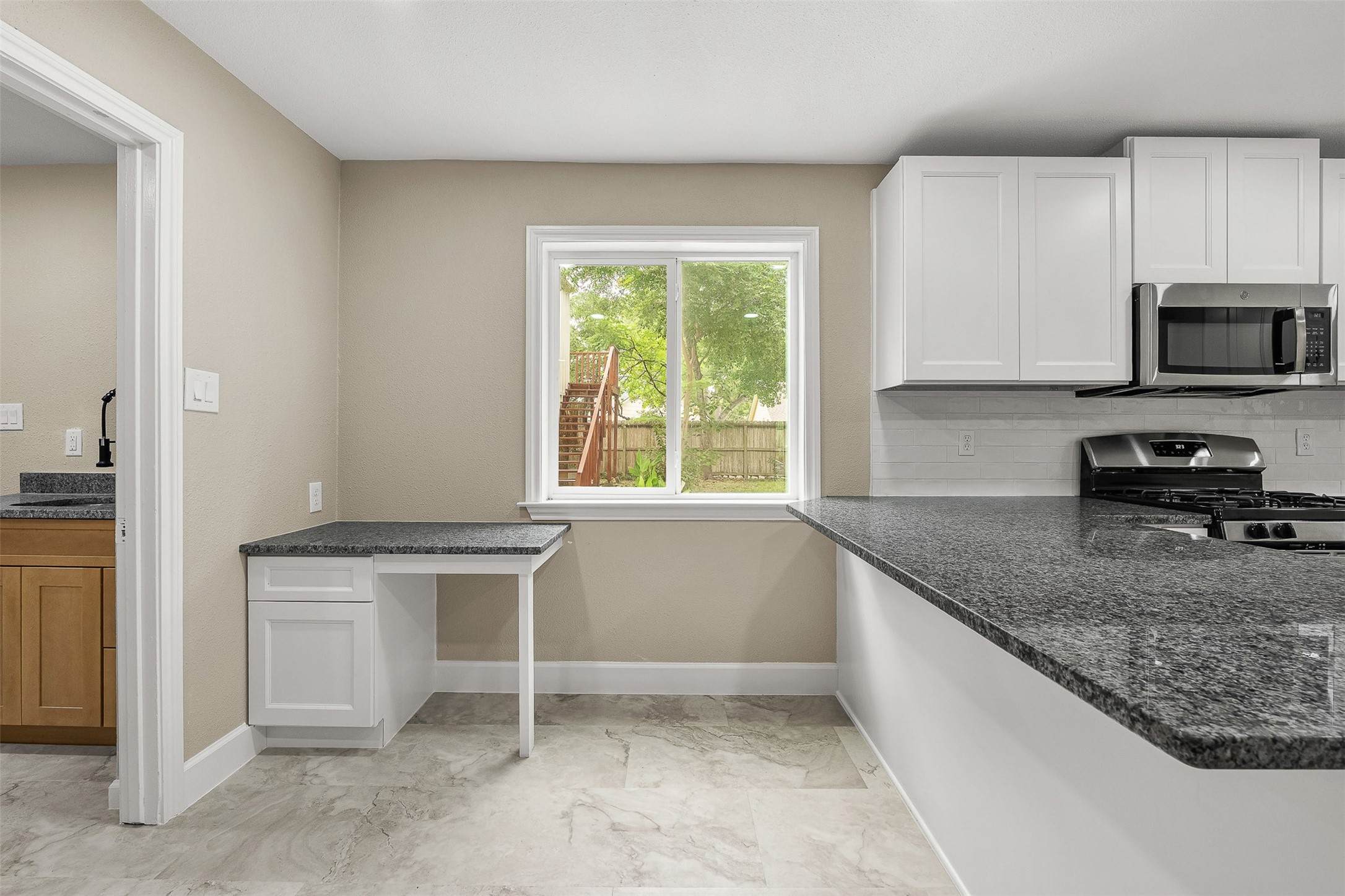 4238 Annawood Circle Spring, TX 77388 - Photo 7 of 46 a kitchen with granite countertop a stove a sink and a microwave