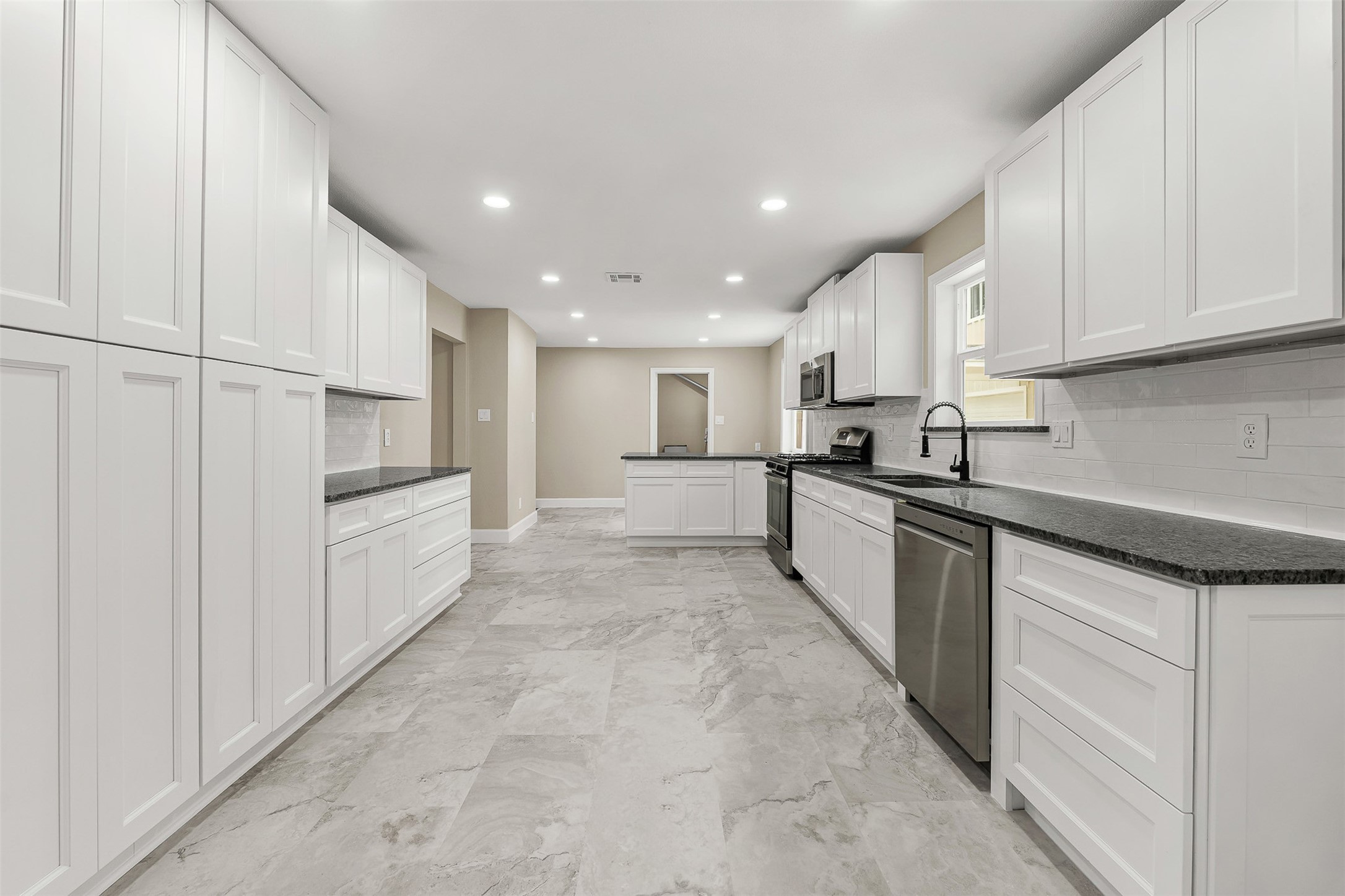 4238 Annawood Circle Spring, TX 77388 - Photo 9 of 46 a large white kitchen with white cabinets and stainless steel appliances