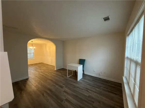 a view of a room with wooden floor and a window