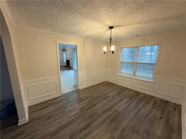 an empty room with wooden floor and cabinet