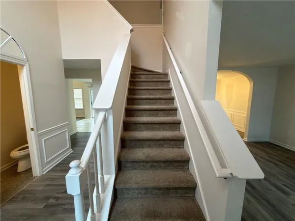 a view of staircase with lots of frames on wall and a window
