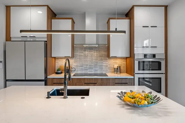 a kitchen with stainless steel appliances a sink and a refrigerator