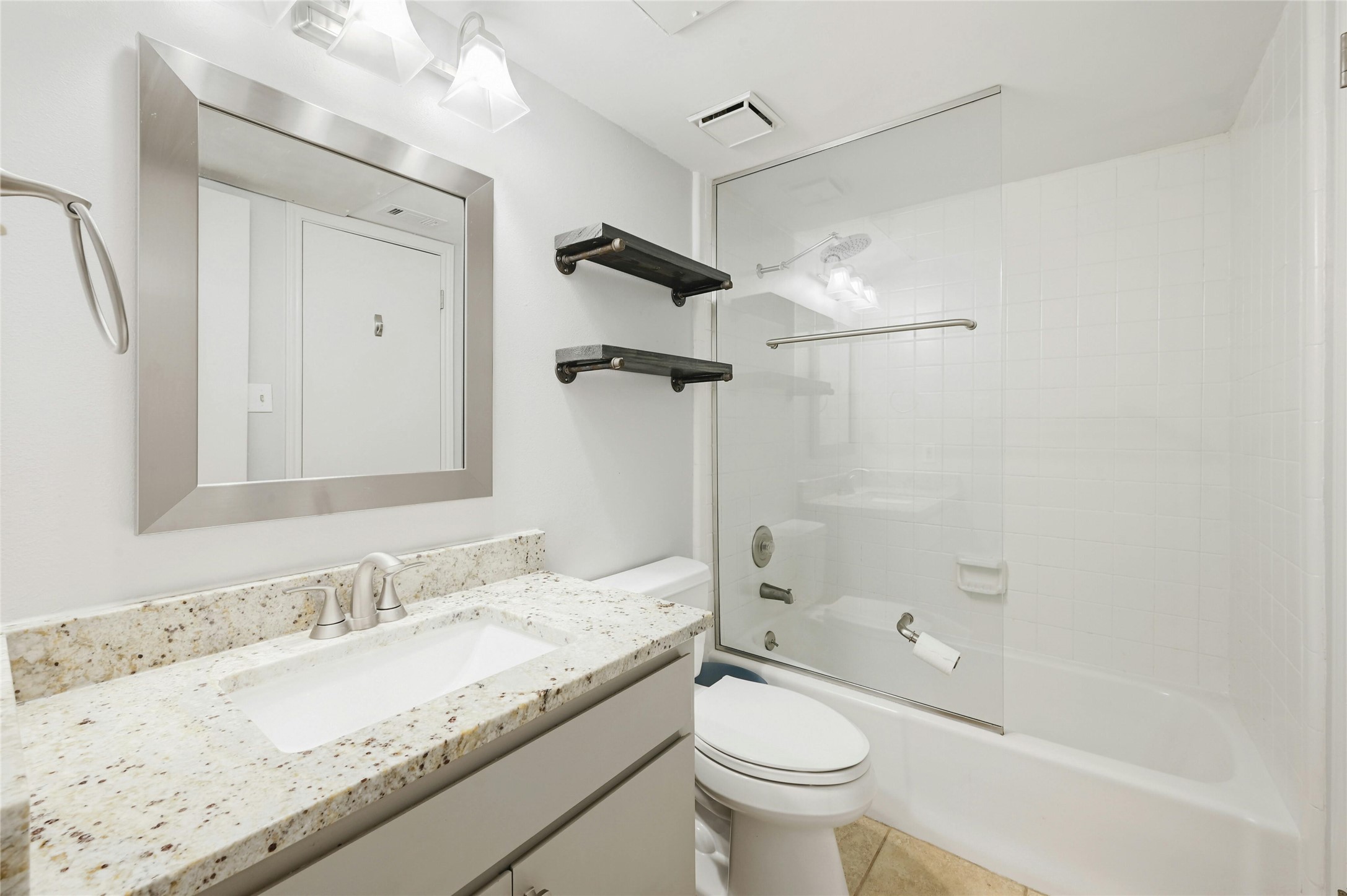9226 Jollyville Road, Unit 221 Austin, TX 78759 - Photo 16 of 20 A pristine bathroom features a shower-tub combo, a sleek vanity, and tiled floors.