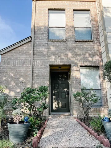 a front view of a house with potted plants