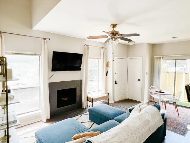 a living room with furniture a fireplace and a flat screen tv