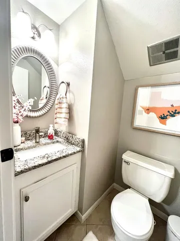 a bathroom with a toilet sink vanity and mirror