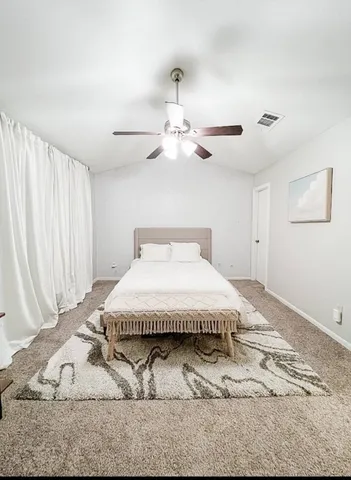 a spacious bedroom with a bed and a window