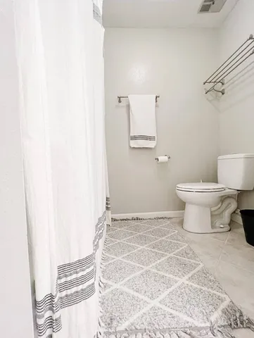 a bathroom with a toilet and a mirror