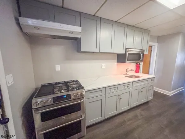 a kitchen with sink a stove and cabinets