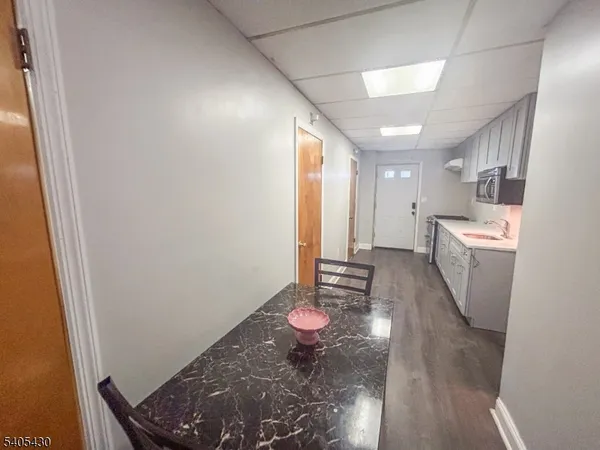 a view of a hallway with furniture and wooden floor