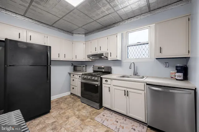 a kitchen with a refrigerator sink and cabinets