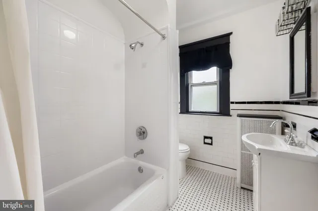 a bathroom with a bathtub sink vanity and mirror