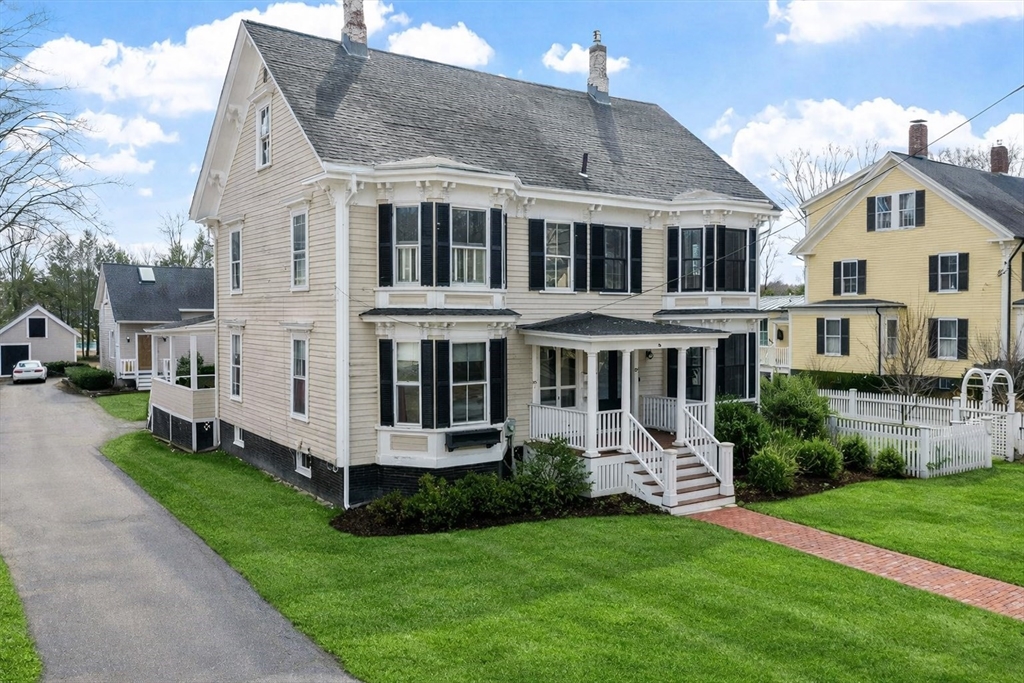 a front view of a house with a yard and trees