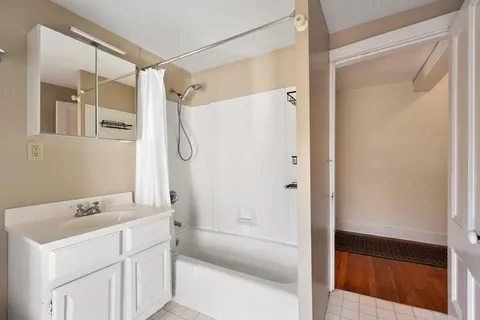 a bathroom with a shower sink and mirror