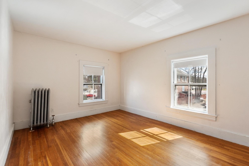 95 Hubbard Street, Unit 95 Concord, MA 01742 - Photo 13 of 22 an empty room with wooden floor and windows