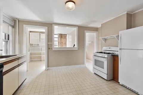a kitchen with granite countertop a refrigerator and a stove top oven