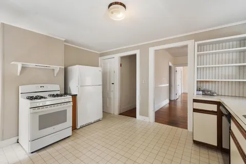 a kitchen with stainless steel appliances granite countertop a refrigerator a stove and a sink with wooden floor