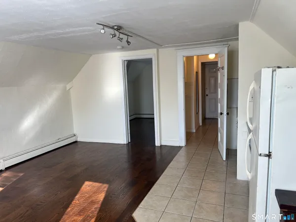 a view of a hallway with wooden floor and closet