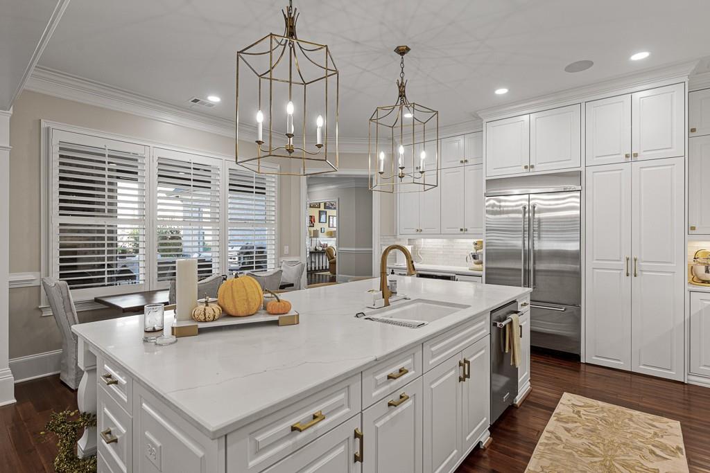 2794 Cork Street Hoschton, GA 30548 - Photo 12 of 51 a kitchen with stainless steel appliances a sink dishwasher a refrigerator a stove and white cabinets with wooden floor